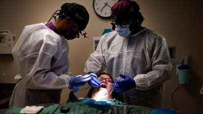 Cindy Clemons, center, receives dental care from Meharry Medical College School of Dentistry third-year student Onyeka Oguagha, left, and oral surgery resident Matthew Moore, right, Tuesday, Sept. 12, 2023, in Nashville, Tenn. Clemons was able to receive treatment after an expansion of the state's Medicaid program. (AP) Cindy Clemons, center, receives dental care from Meharry Medical College School of Dentistry third-year student Onyeka Oguagha, left, and oral surgery resident Matthew Moore, right, Tuesday, Sept. 12, 2023, in Nashville, Tenn. Clemons was able to receive treatment after an expansion of the state's Medicaid program. (AP)