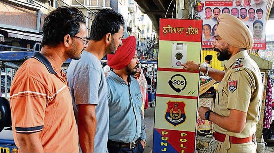 A police official explaining locals the functioning of a CARE station in Ludhiana. (HT PHOTO)