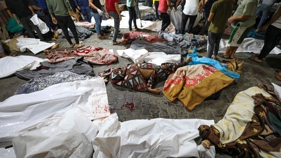 EDITORS NOTE: Graphic content / People gather around bodies of Palestinians killed in Israeli airstrikes on the Ahli Arab hospital in central Gaza after they were transported to Al-Shifa hopsital, on October 17, 2023. (Photo by Dawood NEMER / AFP) (AFP)