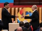 China's President Xi Jinping (L) shakes hands with Russia's President Vladimir Putin.
