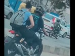 The image shows a woman working on laptop while on a bike. 