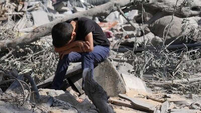 Israel-Hamas War: A Palestinian boy sits on the rubble of the building destroyed in an Israeli airstrike in Bureij refugee camp Gaza Strip. (AP)