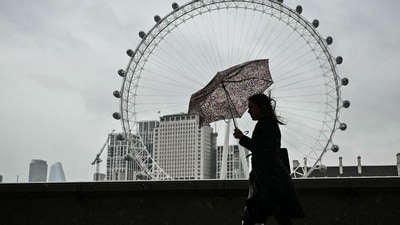 Israel-Hamas War: A pedestrian walks under an umbrella on the Southbank in London as the rain falls. (AFP) Israel-Hamas War: A pedestrian walks under an umbrella on the Southbank in London as the rain falls. (AFP)