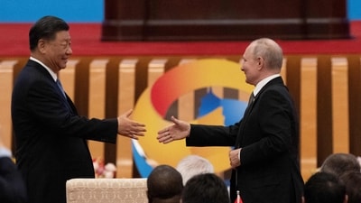 China's President Xi Jinping (L) shakes hands with Russia's President Vladimir Putin. (AFP)