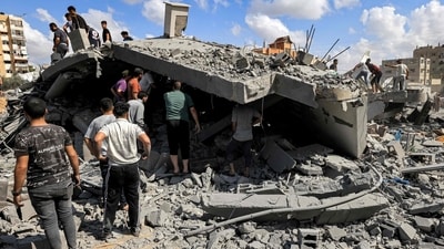 People inspect the remains of a destroyed building following Israeli bombardment in Khan Yunis in the southern of Gaza Strip on October 18, 2023 (Photo by MAHMUD HAMS / AFP) (AFP) People inspect the remains of a destroyed building following Israeli bombardment in Khan Yunis in the southern of Gaza Strip on October 18, 2023 (Photo by MAHMUD HAMS / AFP) (AFP)