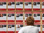 A woman looks at posters showing the pictures of Israeli hostages held by militants A woman looks at posters showing the pictures of Israeli hostages held by militants