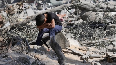 Israel-Hamas War: A Palestinian boy sits on the rubble of the building destroyed in an Israeli airstrike in Bureij refugee camp Gaza Strip. (AP) Israel-Hamas War: A Palestinian boy sits on the rubble of the building destroyed in an Israeli airstrike in Bureij refugee camp Gaza Strip. (AP)