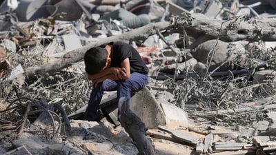 Israel-Hamas War: A Palestinian boy sits on the rubble of the building destroyed in an Israeli airstrike in Bureij refugee camp Gaza Strip. (AP) Israel-Hamas War: A Palestinian boy sits on the rubble of the building destroyed in an Israeli airstrike in Bureij refugee camp Gaza Strip. (AP)