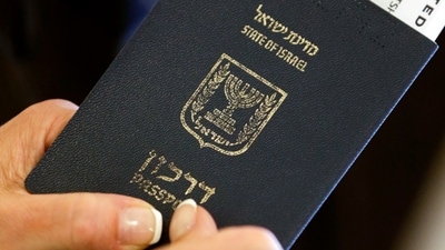 A woman holds her boarding pass in her passport after checking in for her flight. (AP) A woman holds her boarding pass in her passport after checking in for her flight. (AP)