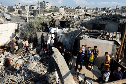 Palestinians gather around the debris of a house destroyed in an Israeli strike, amid the ongoing conflict between Israel and Palestinian Islamist group Hamas, in Khan Younis in the southern Gaza Strip on October 19. (Reuters)