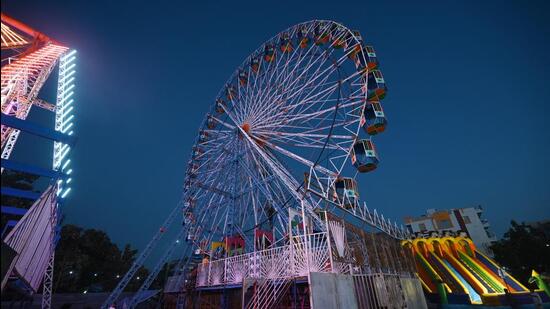 Workers fix the Ferris wheel at Ramlila Maidan in Narela in New Delhi on Thursday. (Sanchit Khanna/HT Photo)