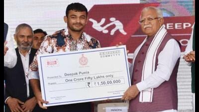 Haryana chief minister Manohar Lal Khattar handing over a cheque for ₹1.5 crore to Deepak Punia at an event in Karnal on Friday. (HT Photo) Haryana chief minister Manohar Lal Khattar handing over a cheque for ₹1.5 crore to Deepak Punia at an event in Karnal on Friday. (HT Photo)