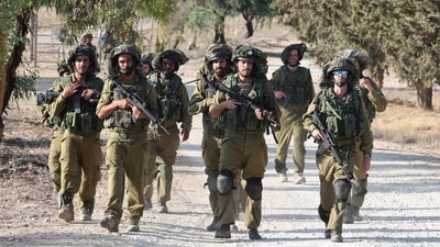 Israeli troops patrol at an undisclosed location along the border with the Gaza Strip on October 19, 2023. (AFP) Israeli troops patrol at an undisclosed location along the border with the Gaza Strip on October 19, 2023. (AFP)