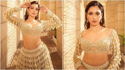 Tamannaah turned showstopper in a beige and pearl white lehenga set featuring a choli with a wide plunging neckline, full-length sleeves adorned in tassels, cropped hem, a fitted bust, scalloped hem, mirror work, and intricate embroidery. A matching heavily embellished lehenga skirt completed the ensemble. (Instagram) Tamannaah turned showstopper in a beige and pearl white lehenga set featuring a choli with a wide plunging neckline, full-length sleeves adorned in tassels, cropped hem, a fitted bust, scalloped hem, mirror work, and intricate embroidery. A matching heavily embellished lehenga skirt completed the ensemble. (Instagram)