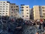 Palestinians gather at the site of an Israeli strike on a house, amid the ongoing conflict between Israel and Hamas.