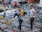 Palestinian carries a child killed in an airstrike on the buildings of Abu Asad family in Deir el-Balah, southern Gaza Strip, Saturday, Oct. 21, 2023. (AP Photo/Hassan Eslaiah)