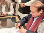 Nawaz Sharif In Pakistan: Pakistan's former Prime Minister Nawaz Sharif (R) signing a legal document after his arrival at the Islamabad airport.