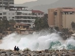 People observe waves breaking on the beach as Hurricane Norma barrels towards the Baja California peninsula.