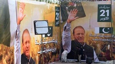 Nawaz Sharif In Pakistan: Workers give final touches next to huge portraits of Pakistan's former prime minister Nawaz Sharif displayed at the venue of his welcoming rally, in Lahore, Pakistan. (AP) Nawaz Sharif In Pakistan: Workers give final touches next to huge portraits of Pakistan's former prime minister Nawaz Sharif displayed at the venue of his welcoming rally, in Lahore, Pakistan. (AP)