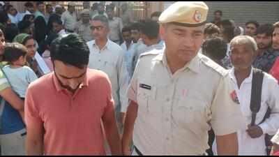 One of the accused being taken by the police from outside an exam centre in Hisar on Saturday. (HT Photo)