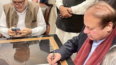 Nawaz Sharif In Pakistan: Pakistan's former Prime Minister Nawaz Sharif (R) signing a legal document after his arrival at the Islamabad airport. (AFP) Nawaz Sharif In Pakistan: Pakistan's former Prime Minister Nawaz Sharif (R) signing a legal document after his arrival at the Islamabad airport. (AFP)