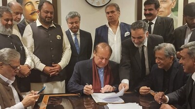 Nawaz Sharif In Pakistan: Pakistan's former Prime Minister Nawaz Sharif (C) signing a legal document after his arrival at the Islamabad airport. (AFP) Nawaz Sharif In Pakistan: Pakistan's former Prime Minister Nawaz Sharif (C) signing a legal document after his arrival at the Islamabad airport. (AFP)
