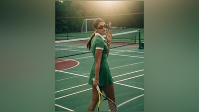 Pooja accessorised the tennis dress with tinted black sunglasses, a silver bracelet adorned with charms, a statement ring, and white lace-up sneakers with green highlights matching her outfit. (Instagram) Pooja accessorised the tennis dress with tinted black sunglasses, a silver bracelet adorned with charms, a statement ring, and white lace-up sneakers with green highlights matching her outfit. (Instagram)