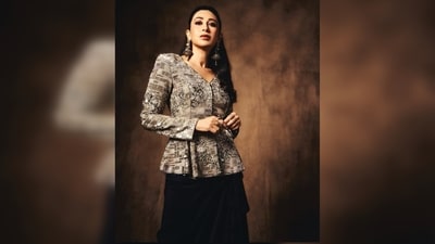 If you feel like experimenting with fashion and want to try something modern yet traditional. Then don't worry, we've got just the right outfit inspiration for you. OG Karisma Kapoor is here to show you how to rock festive fashion with flair. Her stunning outfit features a grey shimmering jacket with captivating prints and sequin detailing. She teamed it with a black skirt with asymmetrical ruffle detailing. Her oversized statement earrings added the finishing touch. With nude eyeshadow, mascara, coloured lashes, highlighted cheeks, mauve lipstick and loose hair, she looked glamorous. (Instagram/@therealkarismakapoor)
