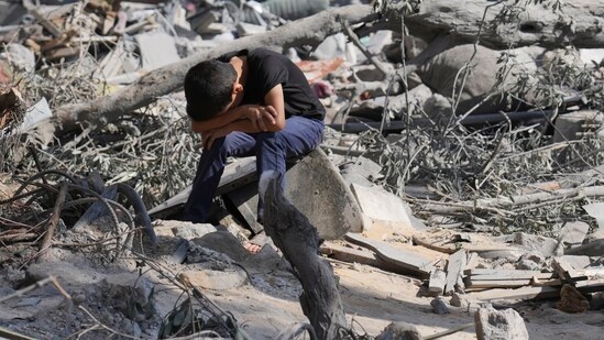 Israel-Hamas War: A Palestinian boy sits on the rubble of the building destroyed in an Israeli airstrike in Bureij refugee camp Gaza Strip. (AP)