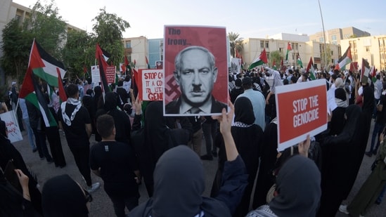 Bahrainis carry placards during a gathering in Manama on October 20, 2023, to express their solidarity with the Palestinian people. (AFP)