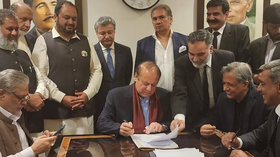 Nawaz Sharif In Pakistan: Pakistan's former Prime Minister Nawaz Sharif (C) signing a legal document after his arrival at the Islamabad airport. (AFP)