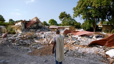 Israel-Hamas War: An Israeli man wearing a prayer shawl prays next to houses destroyed by Hamas militants in Kibbutz Be'eri, Israel. (AP) Israel-Hamas War: An Israeli man wearing a prayer shawl prays next to houses destroyed by Hamas militants in Kibbutz Be'eri, Israel. (AP)