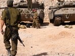 Israeli soldiers gather near Merkava tanks as they man a position at an undisclosed location on the border with Lebanon. (AFP) Israeli soldiers gather near Merkava tanks as they man a position at an undisclosed location on the border with Lebanon. (AFP)