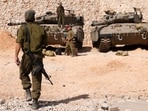 Israeli soldiers gather near Merkava tanks as they man a position at an undisclosed location on the border with Lebanon. (AFP) Israeli soldiers gather near Merkava tanks as they man a position at an undisclosed location on the border with Lebanon. (AFP)