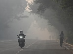 Commuters out on a smoggy morning amid rising air pollution near Mandi House in New Delhi on October 23.