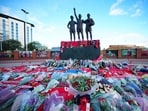 Floral tributes are pictured at the base of the 'United Trinity' sculpture, depicting former Manchester United players George Best, Denis Law and Bobby Charlton, outside Old Trafford.
