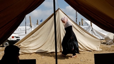 Israel-Hamas War: A woman walks past tents, as Palestinians, who fled their houses amid Israeli strikes, take shelter in a tent camp at a United Nations-run centre in the southern Gaza Strip. (Reuters)