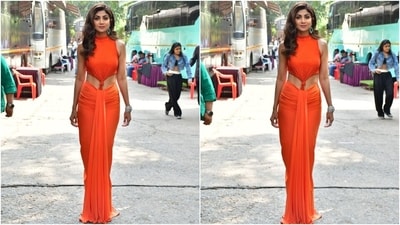 Shilpa's sleeveless gown comes in a striking orange shade and features a raised neckline, shimmering sequin embellishments on the ribbed torso, a cut-out on the waist exposing her toned abs, a dhoti-style skirt with gathered front, and a floor-sweeping hem length. (HT Photo/Varinder Chawla) Shilpa's sleeveless gown comes in a striking orange shade and features a raised neckline, shimmering sequin embellishments on the ribbed torso, a cut-out on the waist exposing her toned abs, a dhoti-style skirt with gathered front, and a floor-sweeping hem length. (HT Photo/Varinder Chawla)