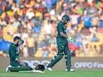 Pakistan's Shadab Khan rests on the ground as his captain Babar Azam (R) walks back to the pavilion Pakistan's Shadab Khan rests on the ground as his captain Babar Azam (R) walks back to the pavilion