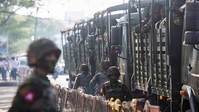 A soldier stand next to military vehicles as people gather to protest against a military coup in Yangon, Myanmar. The Indian state of Nagaland says it has become a refuge for Nagas fleeing coup-hit Myanmar. (REUTERS/File)