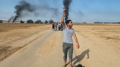 Israel-Hamas War: Palestinians walk away from the kibbutz of Kfar Azza, Israel, near the fence with the Gaza strip. (AP) Israel-Hamas War: Palestinians walk away from the kibbutz of Kfar Azza, Israel, near the fence with the Gaza strip. (AP)