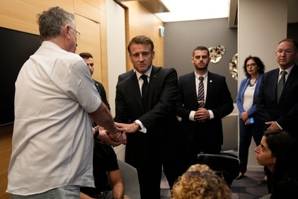 French President Emmanuel Macron, center, meets with Israeli-French nationals who have lost loved ones, as well as families of hostages, at the Ben Gurion airport on October 24. (AP) French President Emmanuel Macron, center, meets with Israeli-French nationals who have lost loved ones, as well as families of hostages, at the Ben Gurion airport on October 24. (AP)