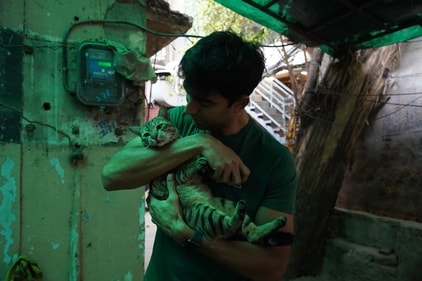 An animal lover at heart, Nishant Dahiya could not resist the urge to pet Pushee, a cat he came across at MKT. (Photo: Gokul VS/HT)