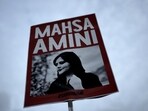 A woman holds a placard with a picture of Iranian woman Mahsa Amini during a protest against her death.