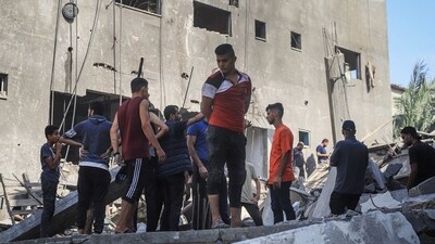 Israel-Hamas War: Palestinians amongst the rubble of a collapsed building following an Israeli airstrike in Khan Younis, Gaza. (Bloomberg)