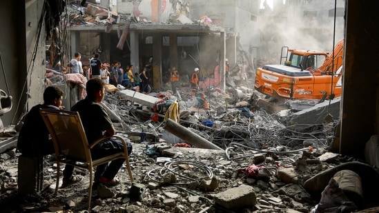 Palestinians search for casualties at the site of Israeli strikes on houses, in Khan Younis, in the southern Gaza Strip,