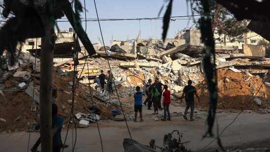 People search the rubble of a building following Israeli strikes on Rafah in the southern Gaza Strip on October 24. (AFP)