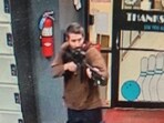 A man identified as a suspect by police points what appears to be a semiautomatic rifle in Lewiston, Maine on October 25.