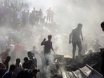 Palestinians inspect the rubble of destroyed buildings following Israeli airstrikes on the town of Khan Younis, southern Gaza Strip, Thursday, Oct. 26, 2023. (AP Photo/Mohammed Dahman)