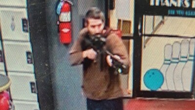 A man identified as a suspect by police points what appears to be a semiautomatic rifle in Lewiston, Maine on October 25. (Reuters)